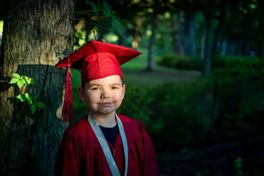 boy in blue academic dress and red academic hat