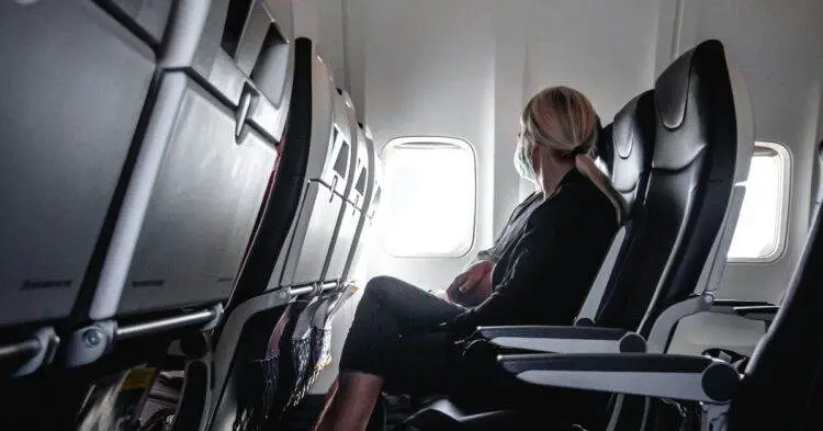 Woman sitting in plane seat near window